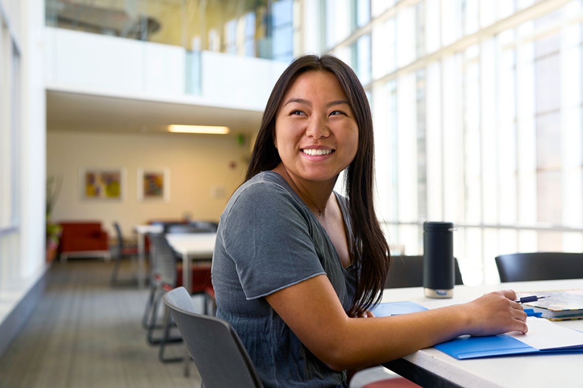 Female asian student smiling and working