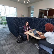 Student studying in academic lounge.